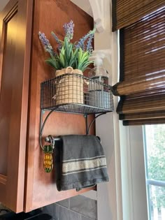 a potted plant sitting on top of a metal shelf next to a kitchen sink