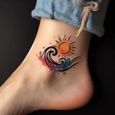 a woman's foot with a colorful tattoo on the side of her body and an orange sun above it