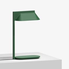 a green lamp sitting on top of a white table