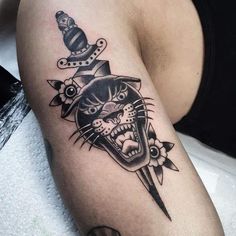 a black and white cat with a knife in it's mouth tattoo on the leg