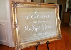 a welcome sign is displayed in front of a mirror on the floor at a wedding