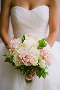 a bride holding a bouquet of pink and white flowers