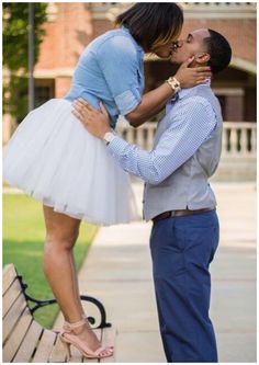 a man and woman kissing on a bench