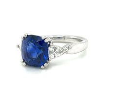 A stunning 4.53 carat cushion shape blue sapphire with exquisite "royal blue" color is set with two spectacular diamonds in this handmade platinum 3-stone engagement ring. Gemstones like this are in a class by themselves. With its deep blue color, exceptional clarity and excellent proportions, sapphires of this caliber are rare and highly sought after, even by gem dealers. This cushion measures 9.17 x 8.68 x 6.39mm is accompanied by Gemological Institute of America Origin Report #2205170372 whic Three Stone Sapphire Ring With Cushion Cut Diamond, Blue Three-stone Cushion Cut Jewelry, Blue Three-stone Cushion-cut Jewelry, Blue Three Stone Cushion Cut Jewelry, Blue Sapphire Three Stone Asscher Cut Ring, Blue Sapphire Ring With Three Stones In Asscher Cut, Deep Blue Color, 3 Stone Engagement Rings, 3 Stone Rings