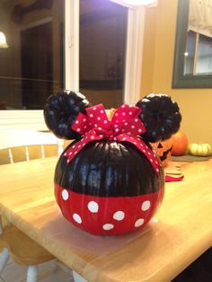 a minnie mouse pumpkin sitting on top of a wooden table