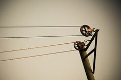 an old fashioned telephone pole with some wires attached to it's sides and the sky in the background