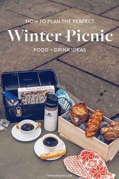 a picnic table with food and drinks on it, including bread in a wooden box