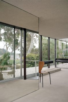 an empty room with large windows and a bench in the middle, near a glass wall