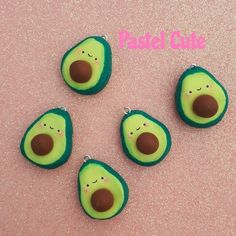 four avocado shaped buttons sitting on top of a pink surface with the words pickle cut above them