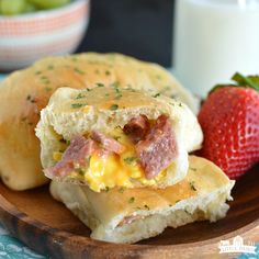 ham and cheese biscuits on a wooden plate with strawberries