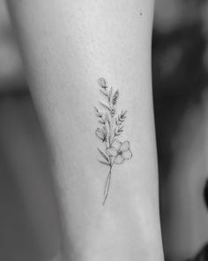 a black and white photo of a flower tattoo on the left side of the leg