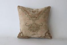 a decorative pillow on a white wall with a brown and tan pattern in the middle