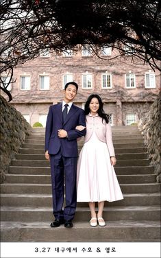 a man and woman standing on steps in front of a building with stairs leading up to them