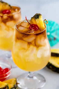 two glasses filled with pineapple punch on top of a table