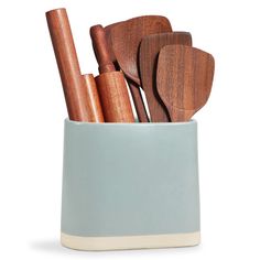 wooden utensils and spoons are in a blue cup on a white background