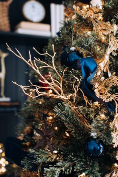 a christmas tree is decorated with blue and gold ornaments