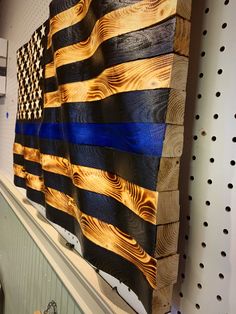 an american flag made out of wood is hanging on the wall