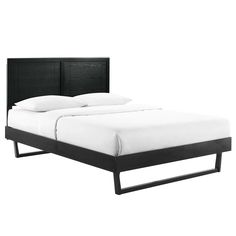 a bed with white sheets and black headboard