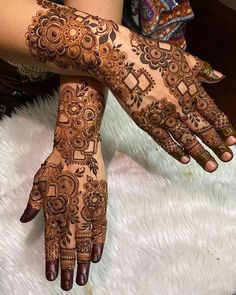 two hands with henna tattoos on them