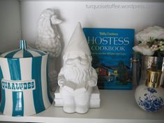 a shelf with books, vases and other decorative items on top of the shelves