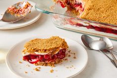 a piece of pie on a plate next to a fork and glass dish full of dessert