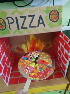 a cardboard pizza box with candy in it and the word pizza painted on top of it