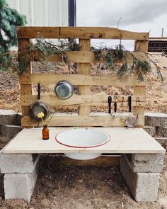 a wooden bench made out of pallets with pots and pans on it