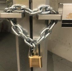 a heart - shaped padlock attached to a metal door with a lock on it