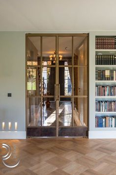 an empty room with bookshelves and candles on the floor in front of it