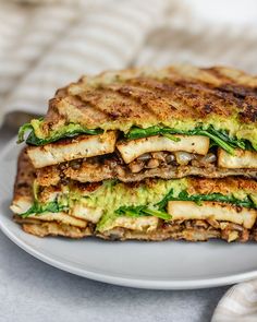 there is a sandwich that has been cut in half on a plate with a fork