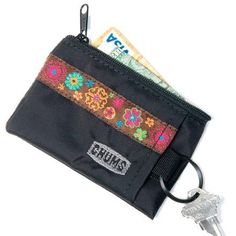 a small wallet with a keychain hanging from it's side and some money sticking out of the pocket