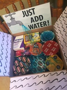 a box filled with assorted items sitting on top of a wooden chair next to a sign that says just add water