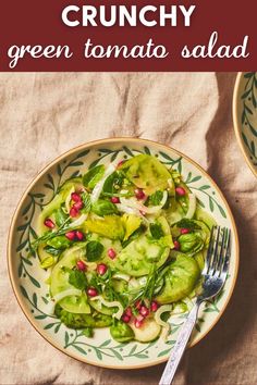 a white plate topped with cucumber and pomegranate salad next to a fork