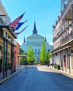 an empty street in front of a church with flags flying from it's windows