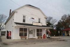 an old white building sitting on the side of a road