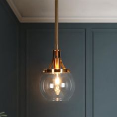 a light fixture hanging from the ceiling in a room with blue walls and wood flooring