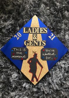 a blue and gold graduation cap with the words ladies & gents on it in black lettering