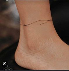 a woman's foot with a small wave tattoo on the side of her ankle