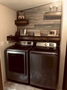 a washer and dryer in a small room with wood wall behind them,