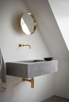 a bathroom sink sitting under a mirror next to a wall mounted faucet in a bathroom