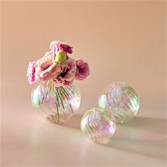 two vases with flowers in them sitting on a table