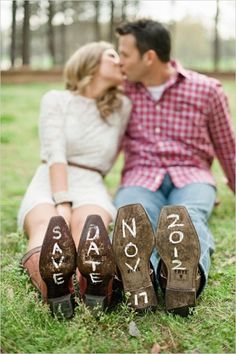 a man and woman kissing in front of shoes with words written on the soles