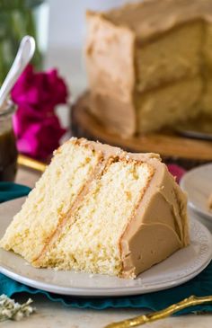 a slice of cake on a plate with the rest of the cake in the background