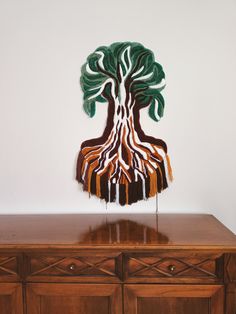 a wooden table topped with a tree sculpture on top of it's sideboard