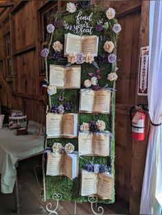 an old book is decorated with flowers and moss for a wedding reception at the barn