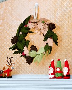 a wreath is hanging on the mantle next to christmas decorations