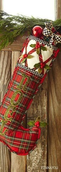 a christmas stocking hanging from the side of a wooden wall next to a window