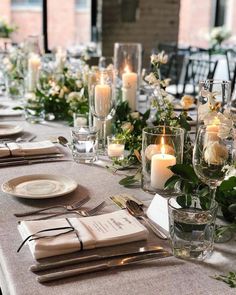 the table is set with place settings, candles and napkins for an elegant dinner