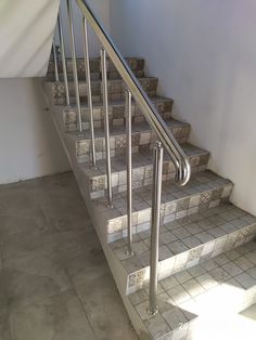 a set of stairs with tiled flooring and handrails