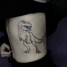 a drawing of a dinosaur on the side of a woman's ribcage